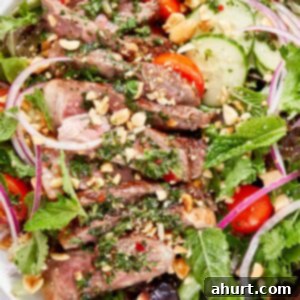 Vibrant Thai Beef Salad 15 Thai beef salad with sliced seared steak, mixed greens, cucumber, cherry tomatoes, red onion, fresh herbs, and chopped peanuts.