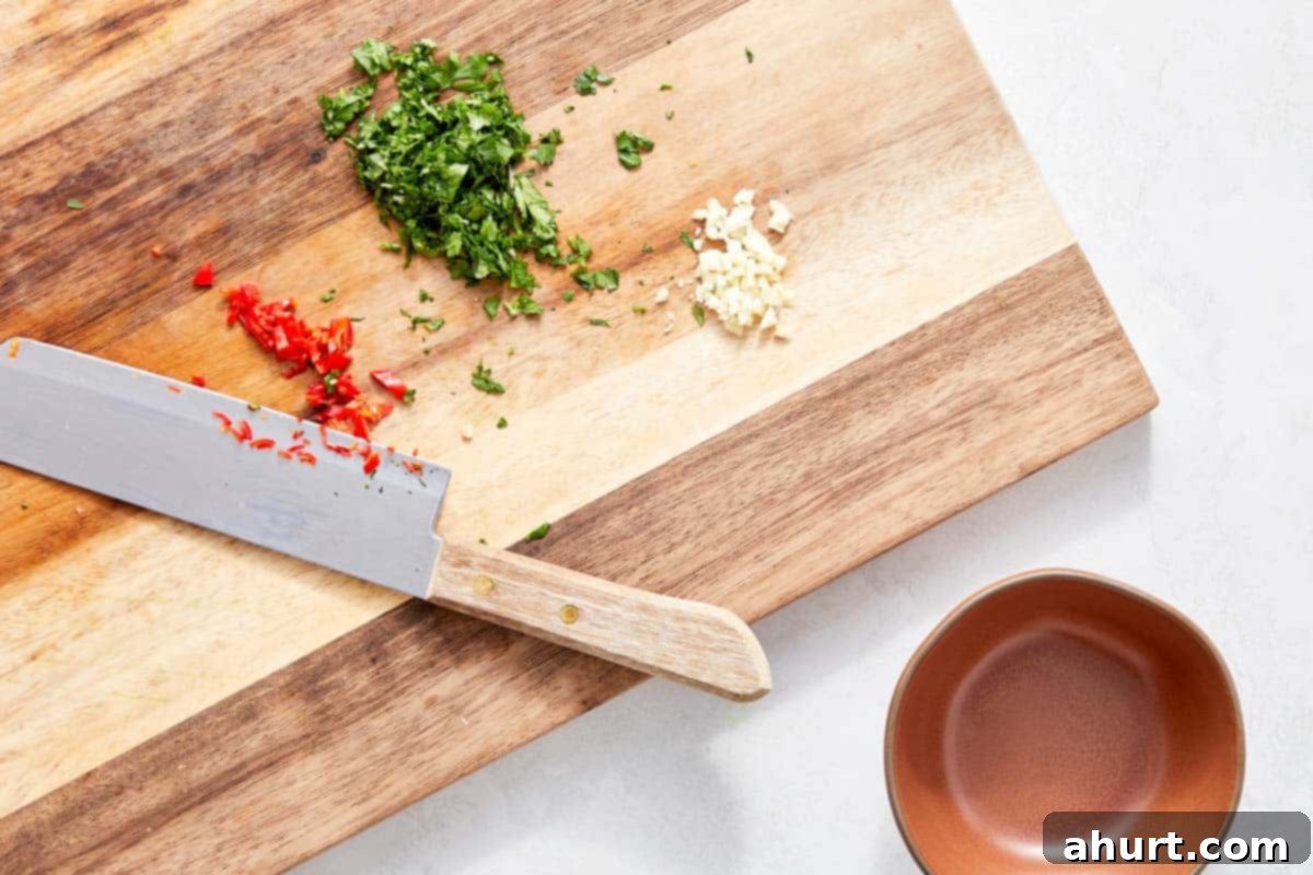 Vibrant Thai Beef Salad 4 Finely chopped chili, cilantro, and minced garlic on a cutting board, ready for the dressing.