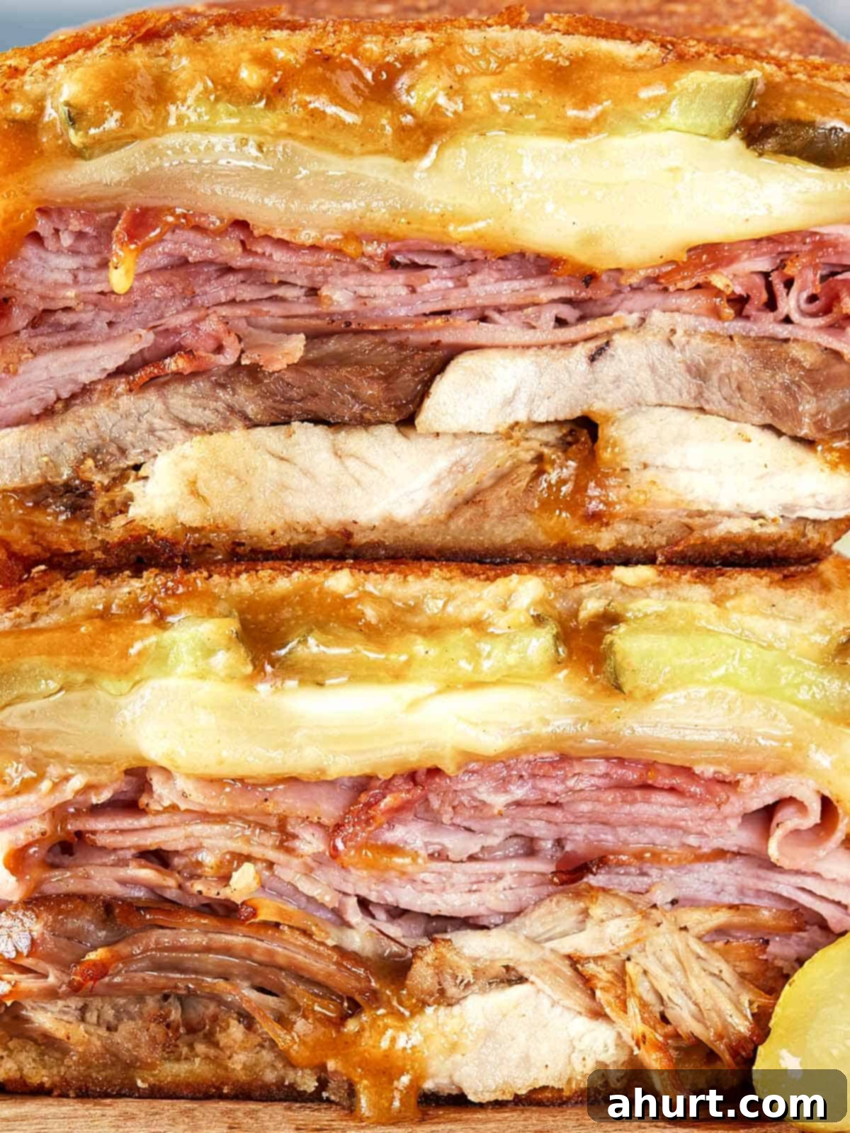 The Iconic Pressed Cuban 2 Close-up of a perfectly stacked and pressed Cuban sandwich, showcasing layers of succulent roast pork, smoky ham, melted Swiss cheese, and vibrant pickles, all nestled within crispy Cuban bread.