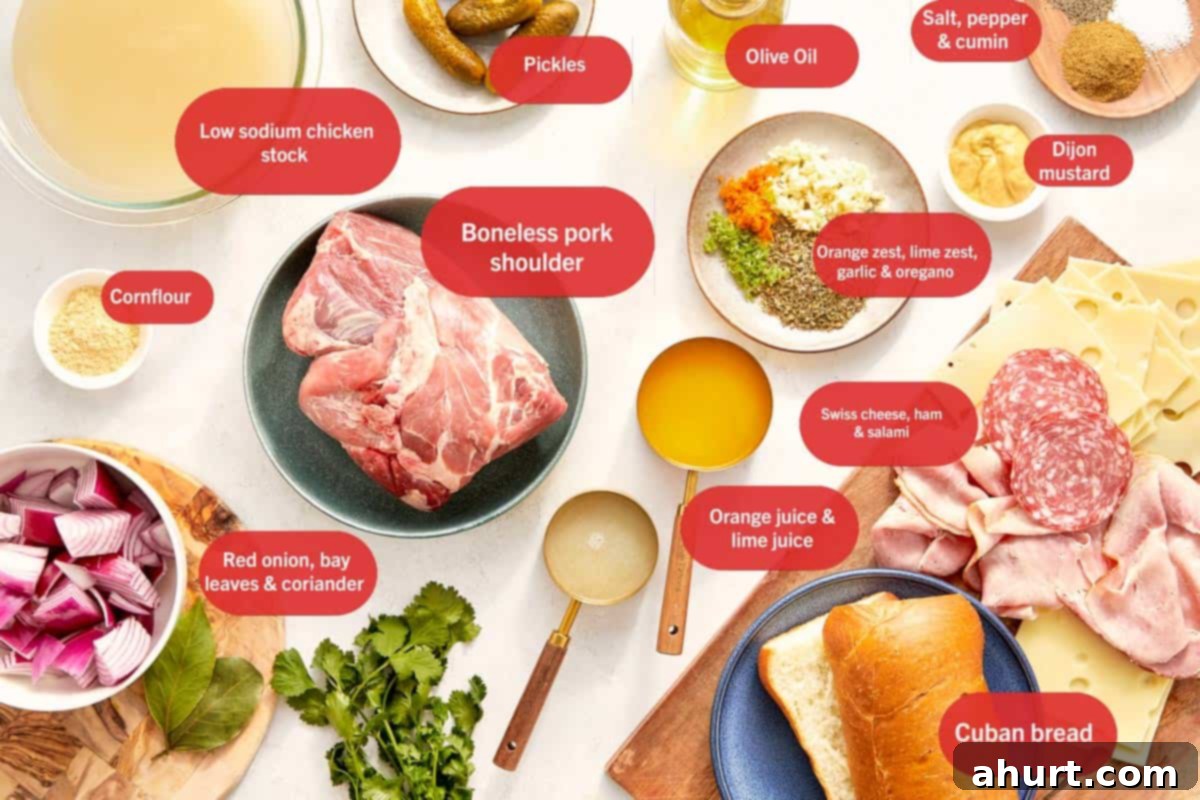 The Iconic Pressed Cuban 3 All essential ingredients for a Cuban sandwich laid out on a rustic wooden table, including Cuban bread, sliced roast pork, ham, Swiss cheese, pickles, mustard, and marinade components.