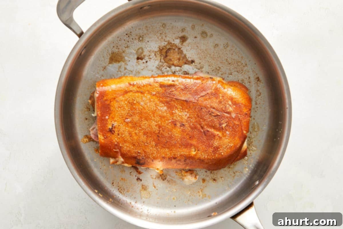 The Iconic Pressed Cuban 8 A Cuban sandwich being perfectly toasted and pressed in a hot skillet, with a heavy pan on top to ensure a crispy golden crust and melted cheese.