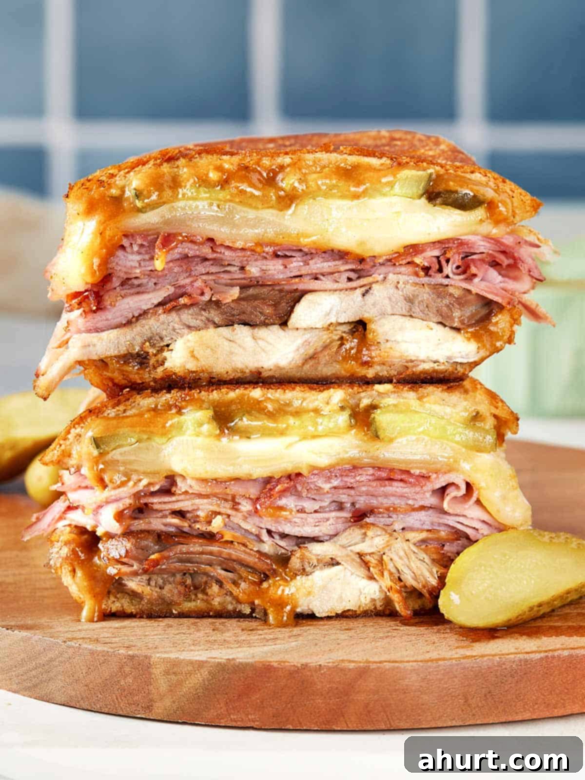 The Iconic Pressed Cuban 10 A tall, perfectly stacked Cuban sandwich, showcasing the generous layers of meat and cheese before being pressed, ready to be enjoyed.