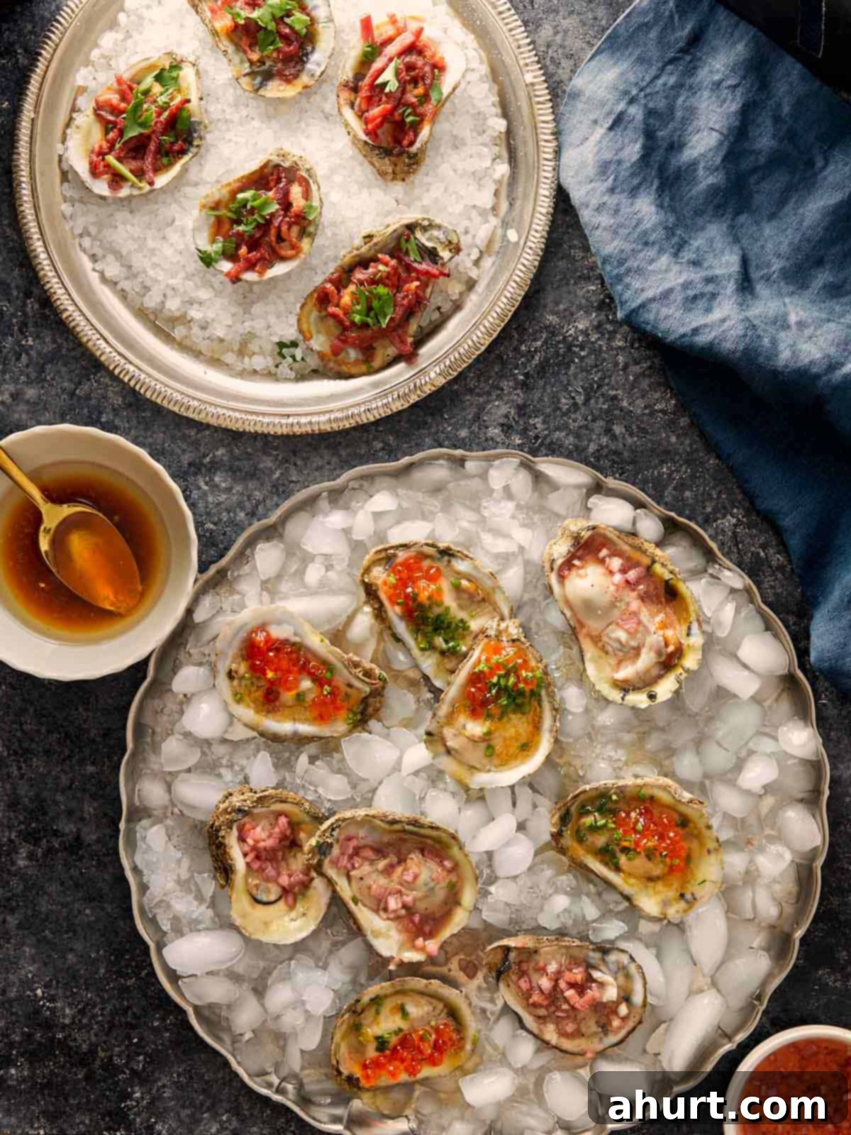 Plates of oysters served three ways, with toppings like red onion, herbs, and roe on ice and salt.