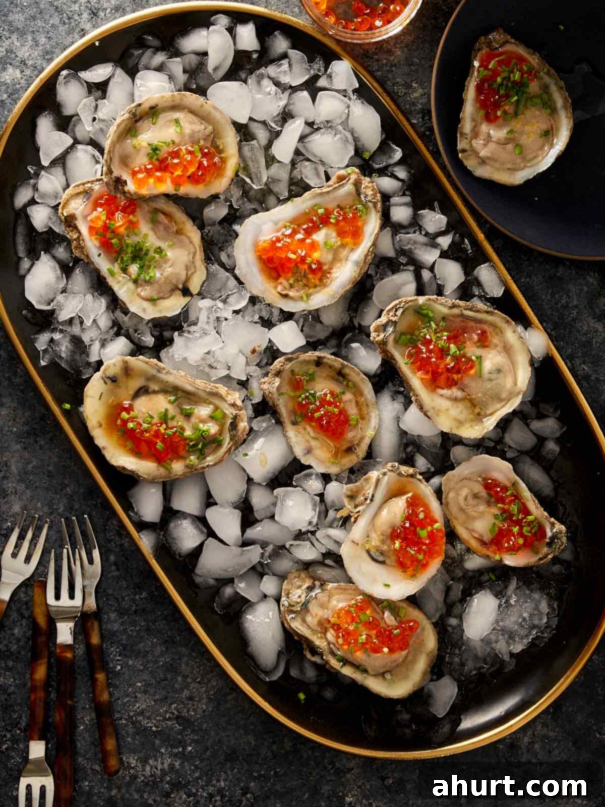 Oysters on the half shell with salmon roe and chives served on ice.