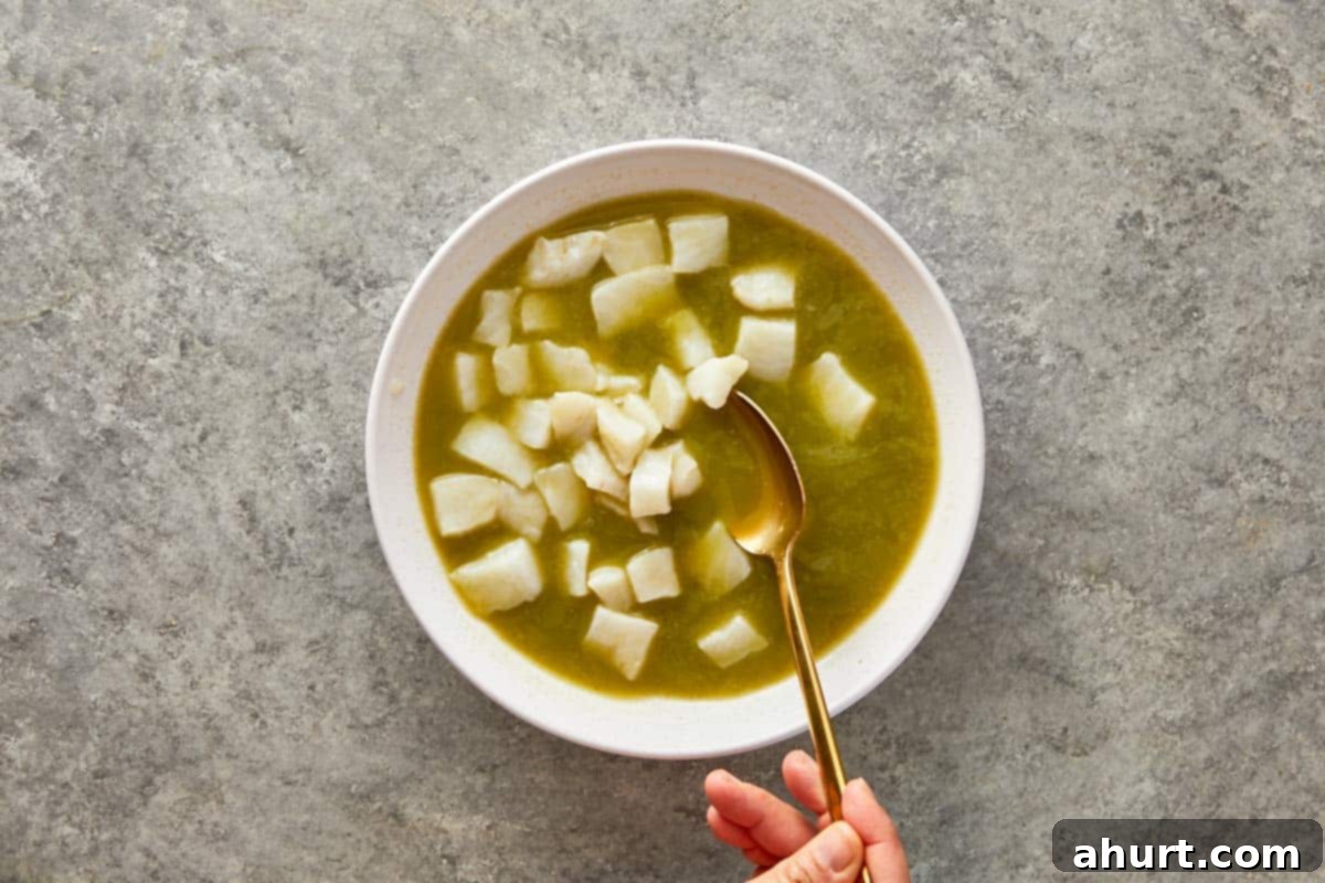 Fresh diced white fish being stirred into the cold marinade.