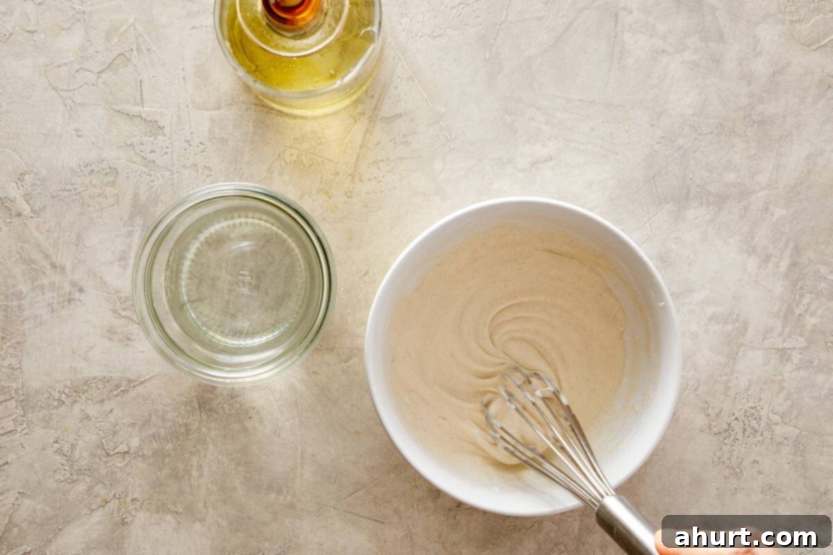 A bowl of smooth batter with a whisk.