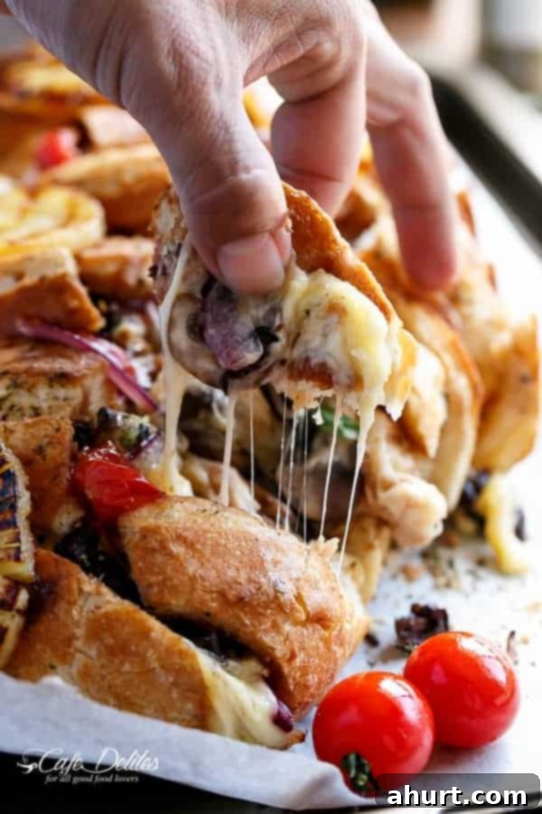 Loaded BBQ Chicken Pizza Pull-Apart Bread 3 A hand pulling a cheesy piece from the Barbecue Chicken Pizza Stuffed Bread.