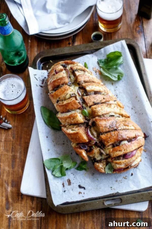 Loaded BBQ Chicken Pizza Pull-Apart Bread 4 Barbecue Chicken Pizza Stuffed Bread fresh out of the oven on a baking tray lined with parchment paper.