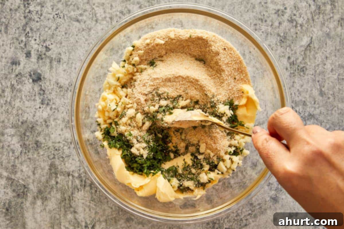 Mixing softened butter, chopped garlic, parsley, salt, and breadcrumbs in a bowl to make garlic parsley butter.