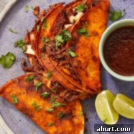 Crispy beef birria tacos with melty cheese and a rich red chile broth for dipping—bold, cheesy, and full of flavor.