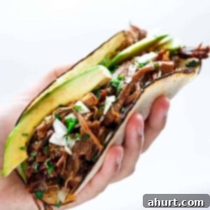 Slow Cooker Barbacoa Short Rib Tacos in hand, showcasing incredibly tender, fall-apart beef