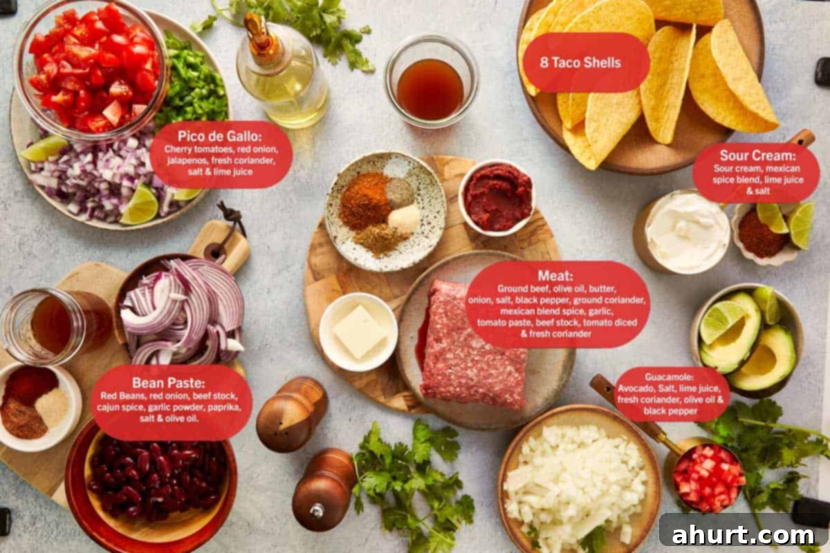 Various fresh ingredients for beef tacos laid out on a wooden table, including ground beef, beans, avocado, tomatoes, onions, and spices.