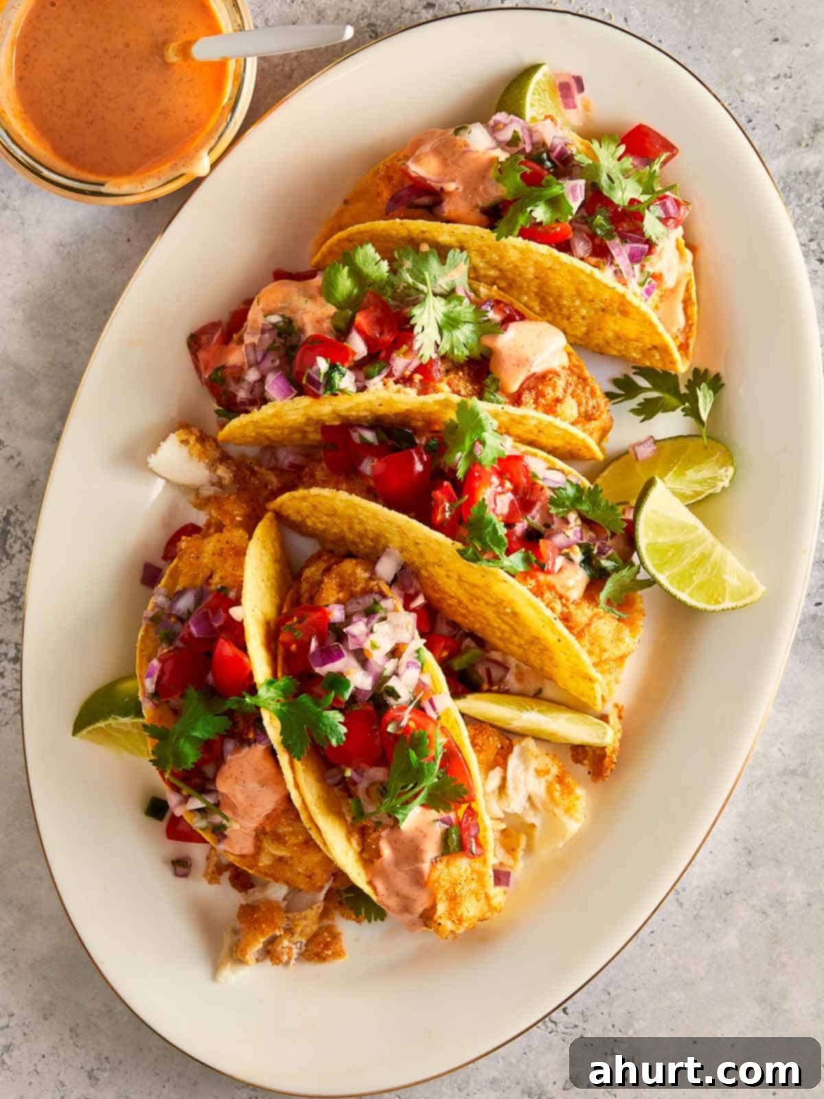 Golden Crispy Fish Tacos 10 Plate of crispy fish tacos with pico de gallo, spicy mayo, cilantro, and lime wedges