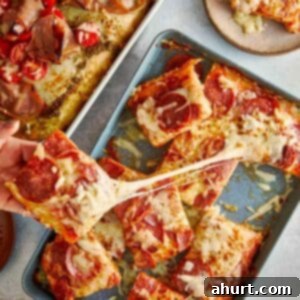 Focaccia-Style Pizza 13 Hand pulling a cheesy slice of focaccia pizza.