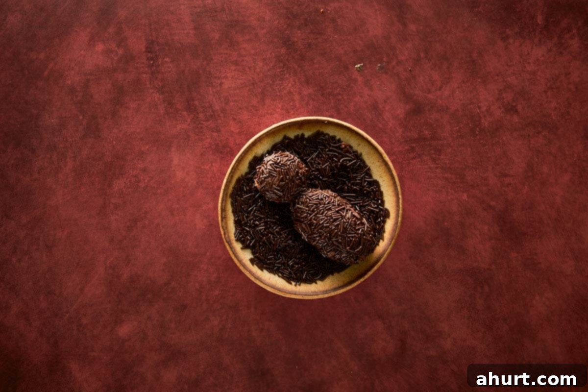 Shaping the chocolate sprinkle–coated spider body using cake crumbs and ganache.