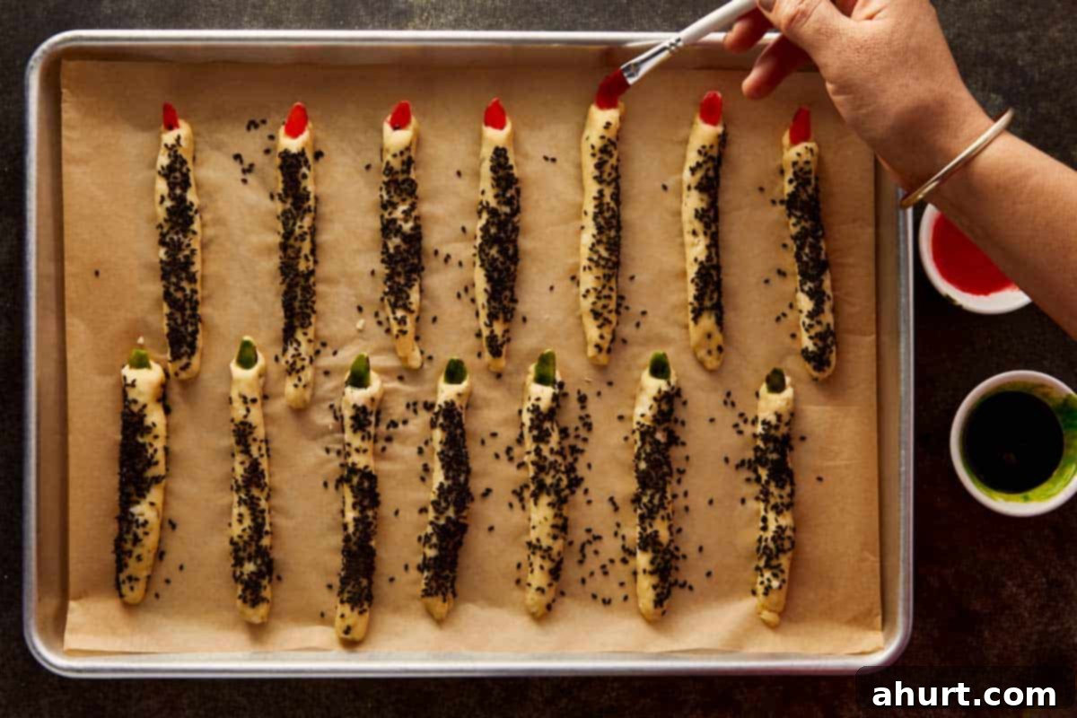 Hand painting almond “nails” red and green with food coloring for a creepy, polished look.
