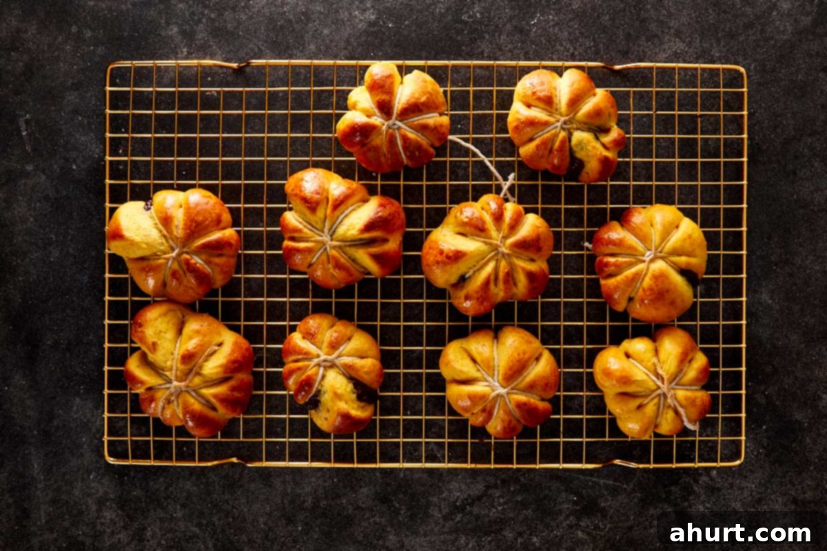 Freshly baked pumpkin breads cooling on a wire rack, golden and perfectly shaped.