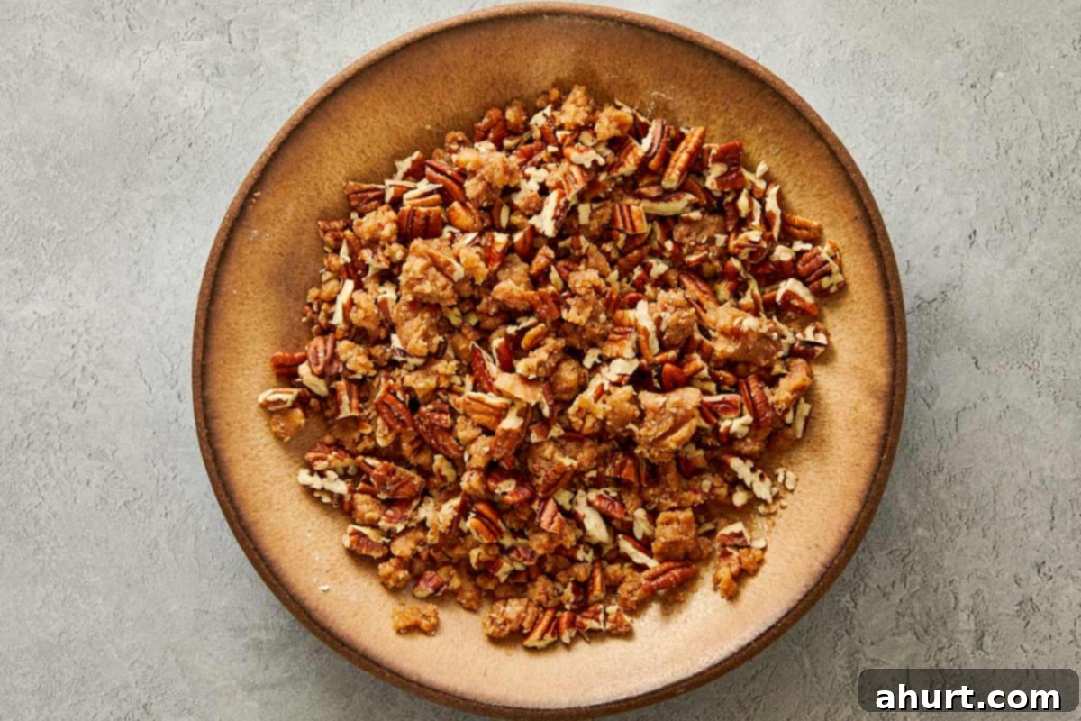 Baking dish filled with sweet potato casserole topped with a chunky brown sugar pecan streusel before adding marshmallows