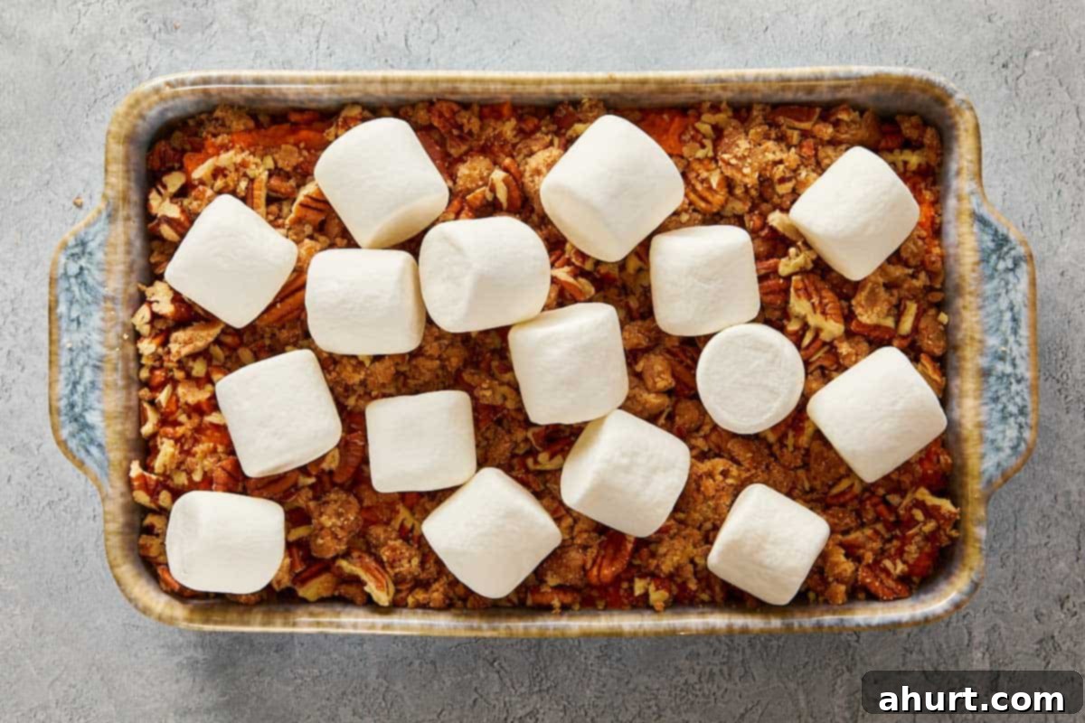 Overhead view of a sweet potato casserole with a layer of large, toasted marshmallows across the top.