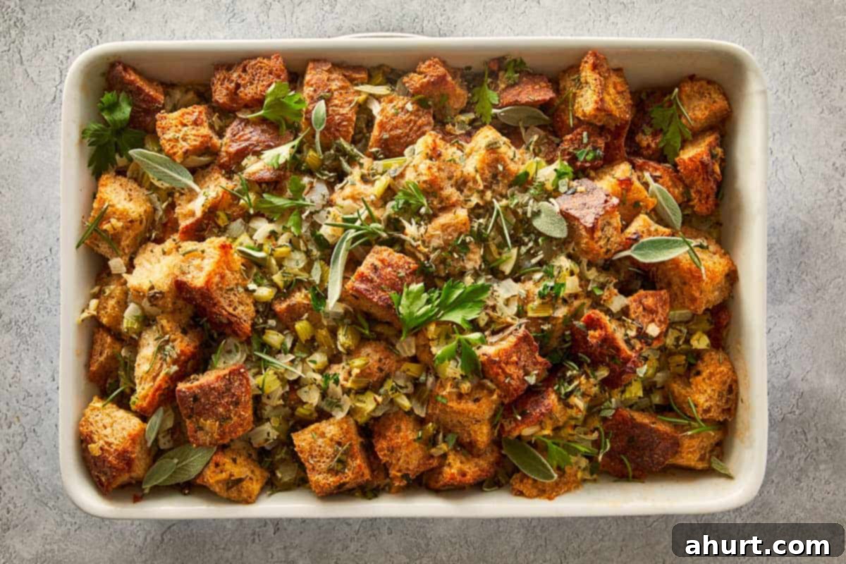 Classic Buttery Herb Stuffing 11 Baked buttery herb stuffing in a white casserole dish, garnished with fresh sage and parsley, a perfect holiday side dish.