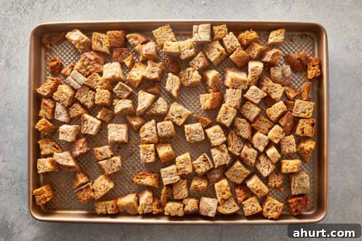 Classic Buttery Herb Stuffing 4 Toasted bread cubes spread out on a baking sheet, ready to be used as the base for herb stuffing.