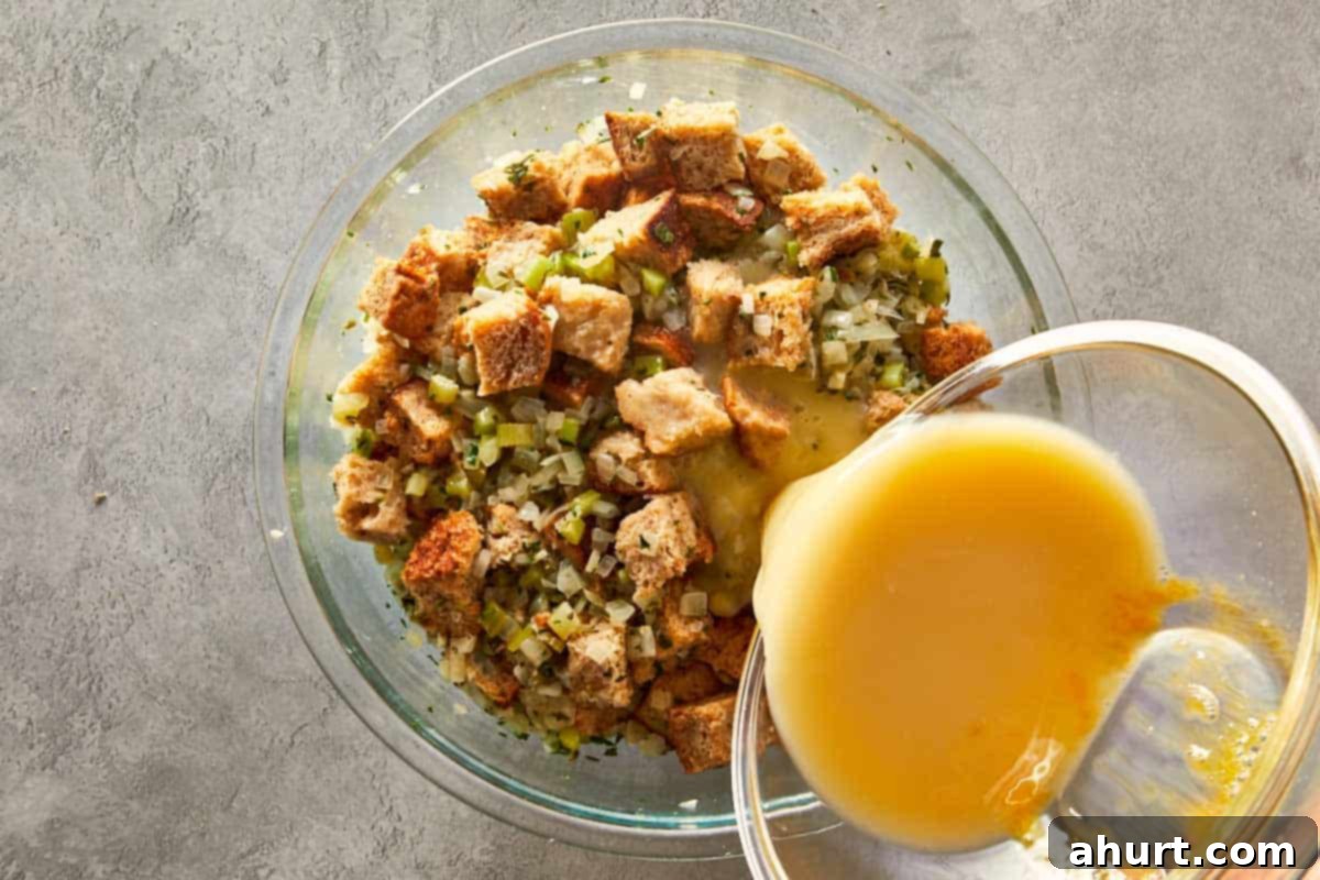 Classic Buttery Herb Stuffing 9 Pouring beaten eggs into the bowl of bread and vegetable mixture to bind the classic herb stuffing ingredients.