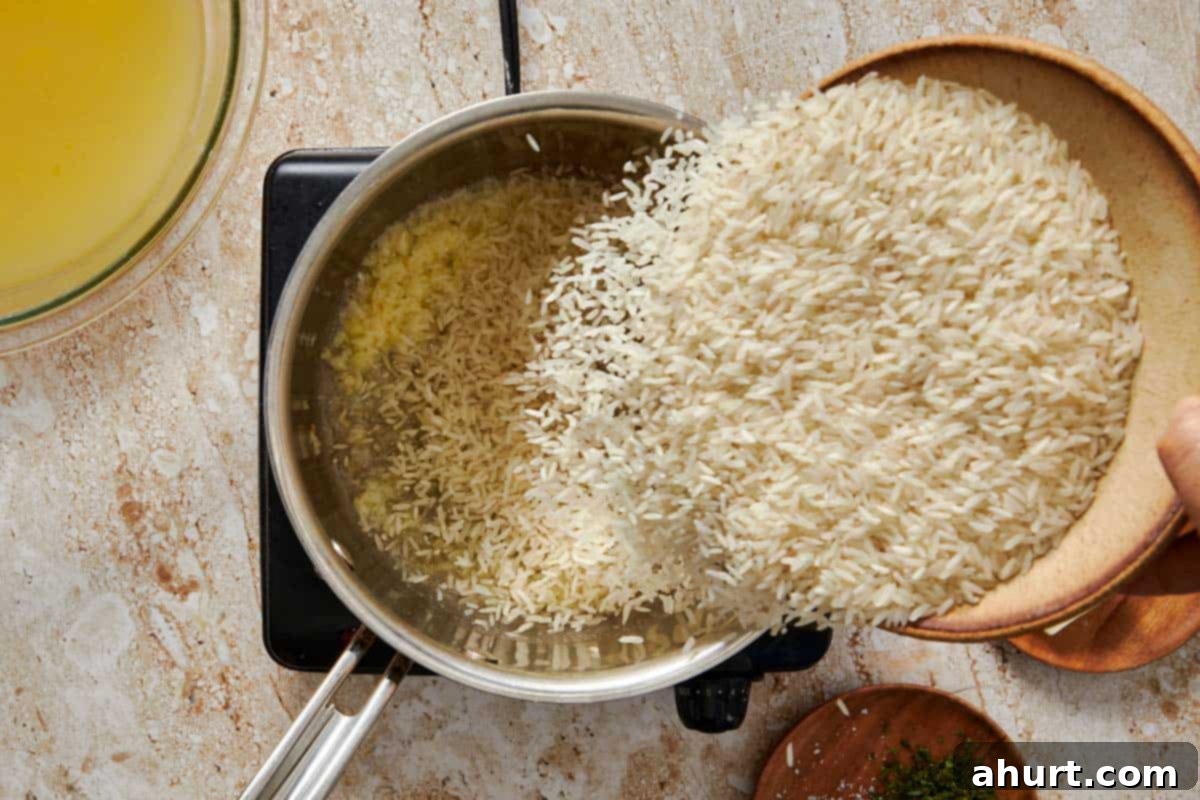 Simple and Flavorful Garlic Butter Rice 5 Uncooked white rice being poured into a pot where garlic and butter are sautéing, preparing to be coated.