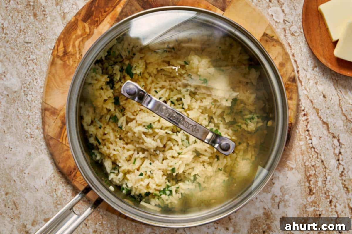 Simple and Flavorful Garlic Butter Rice 9 The pot of cooked rice, now covered again, resting off the heat to fully steam and absorb any remaining moisture.