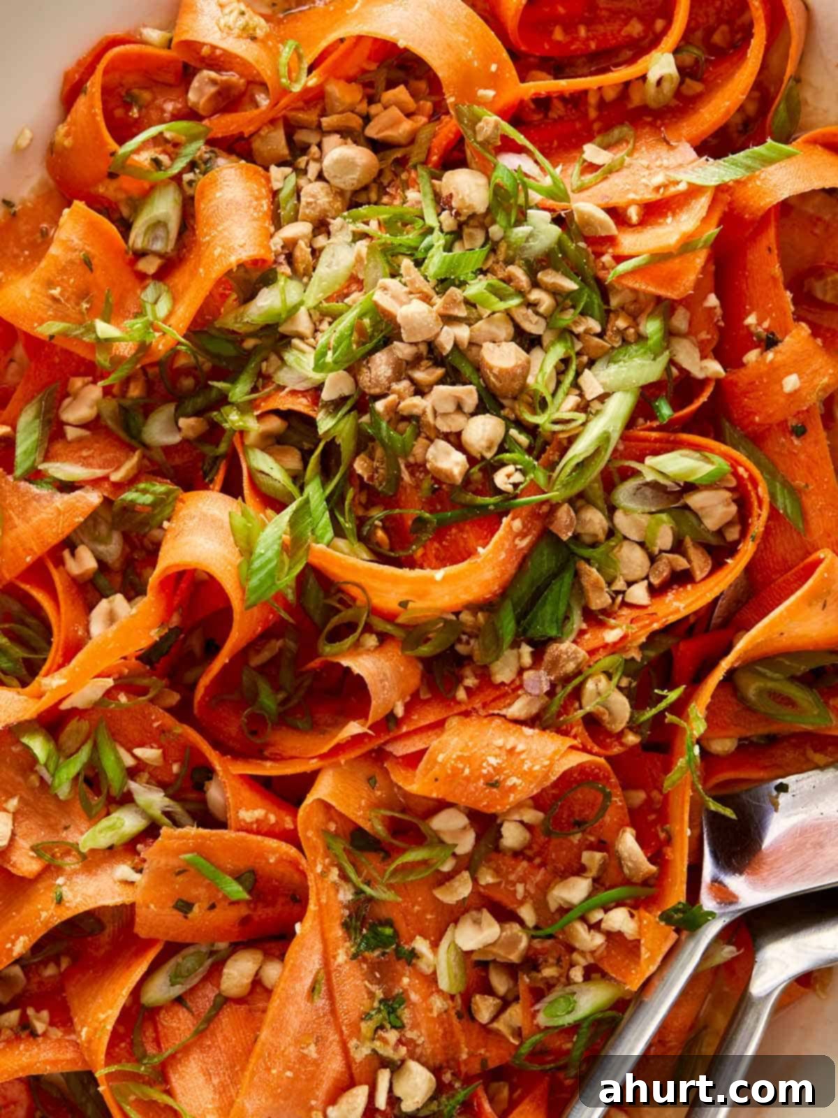 Ginger Peanut Carrot Slaw 2 Close-up top-down view of a vibrant Asian Carrot Salad, garnished generously with roasted peanuts and fresh green onions
