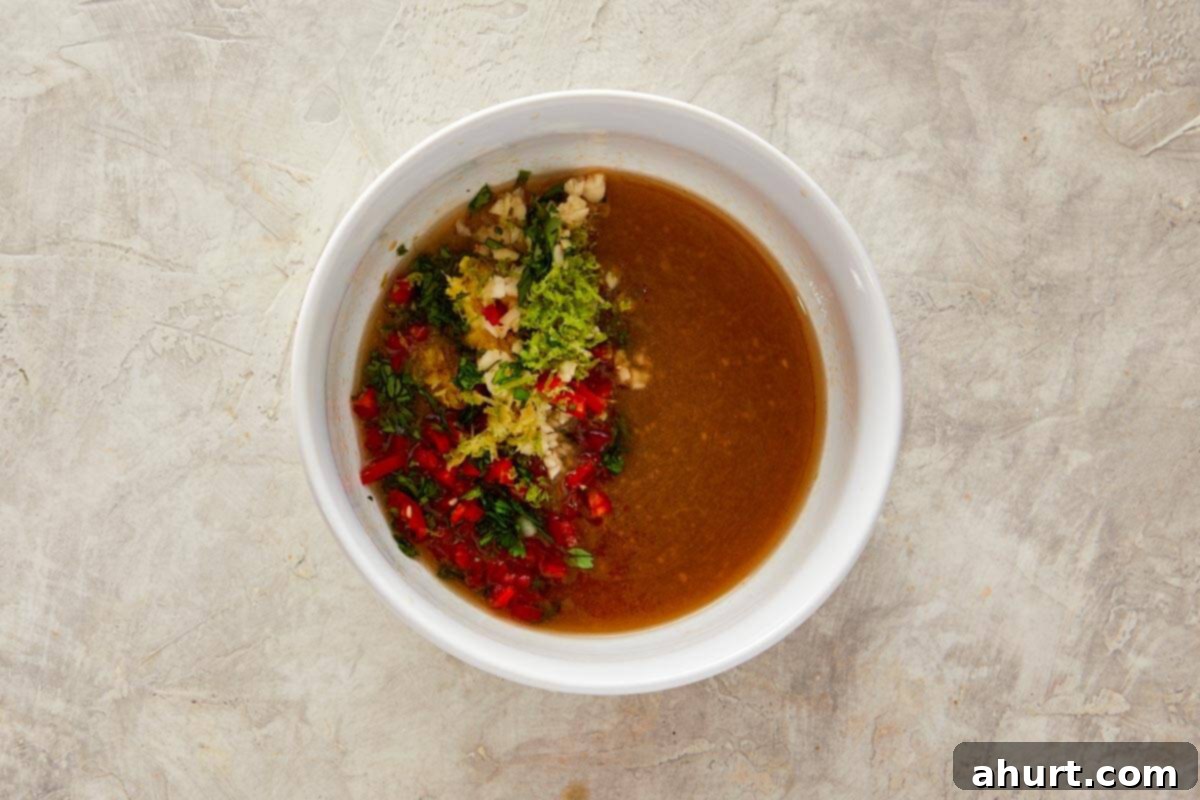 Ginger Peanut Carrot Slaw 6 A close-up of the seasoning mix, including finely chopped red chili, lemon and lime zest, minced garlic, grated ginger, and fresh coriander