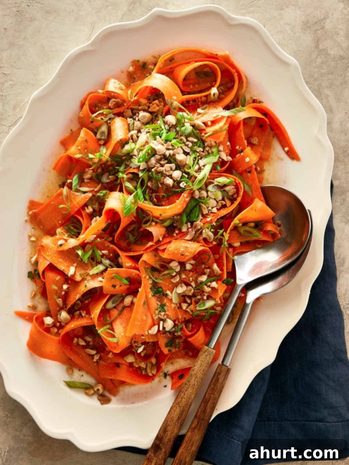Ginger Peanut Carrot Slaw 10 Top-down shot of the finished Asian Carrot Salad served in a rustic bowl with a spoon resting in it, showcasing its vibrant colours