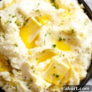 Master Your Thanksgiving 30 Recipes for a Perfect Feast 11 A close-up view of a bowl of Easy Creamy Mashed Potatoes, perfectly smooth and garnished with fresh parsley.