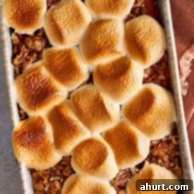 Master Your Thanksgiving 30 Recipes for a Perfect Feast 13 An overhead view of a luscious sweet potato casserole, topped with golden toasted marshmallows and a subtle pecan crumble around the edges, fresh from the oven.