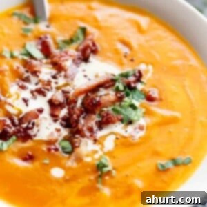 Master Your Thanksgiving 30 Recipes for a Perfect Feast 10 A comforting bowl of thick and creamy pumpkin soup, garnished with a swirl of cream and fresh herbs.