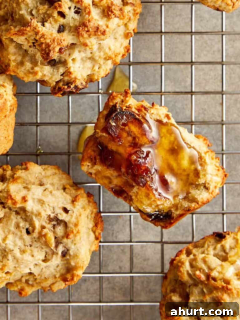 a collection of muffins sitting spaced out on a wire rack cooling close up shot showing honey glazed over half a muffin