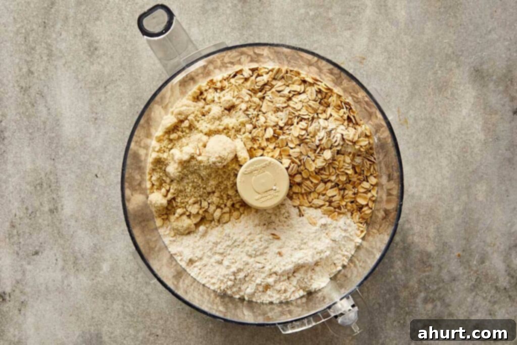 a top down photo of a food processor with dry ingredients in it ready for blending