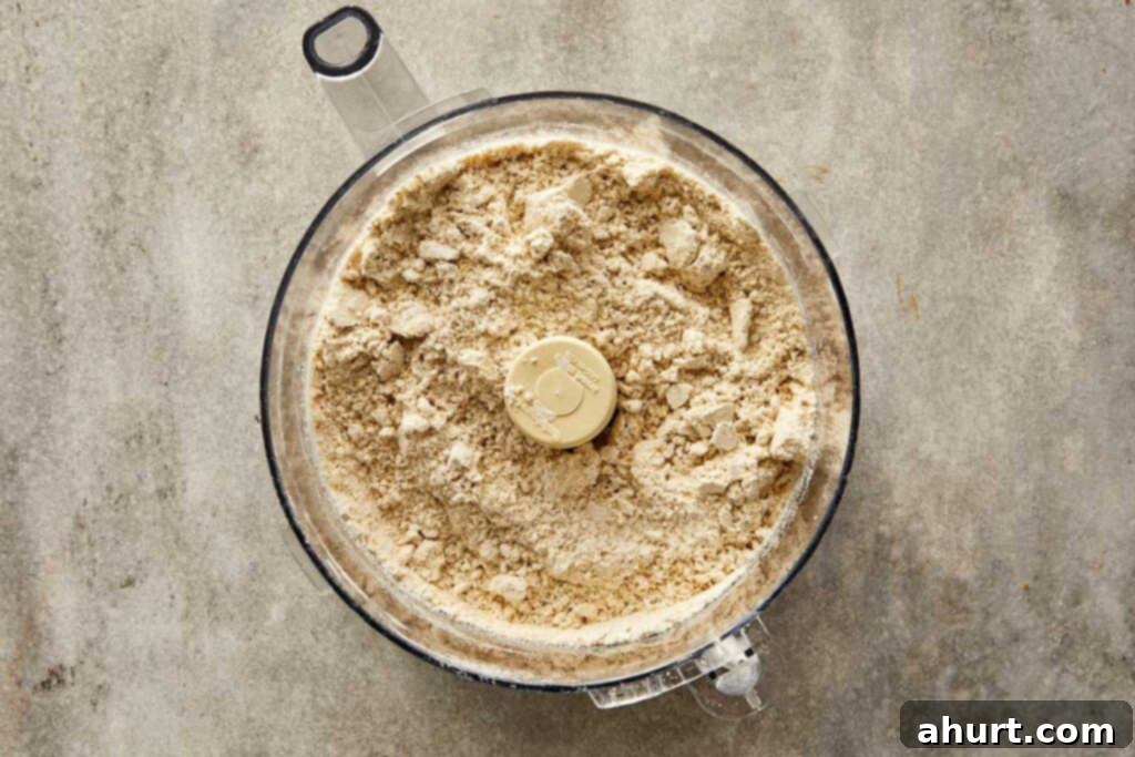 a top down photo of a food processor with dry ingredients that have been blended