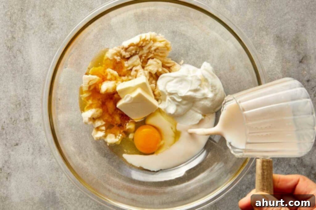 a top down photo of a glass mixing bowl with egg and milk butter and vanilla in it.