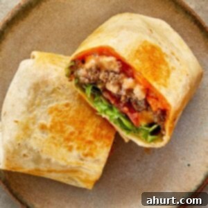 Cheeseburger Bliss Wrap 21 a top down shot of two halves of cheeseburger wrap with meat melted cheese and sauce close up resting on a chopping board