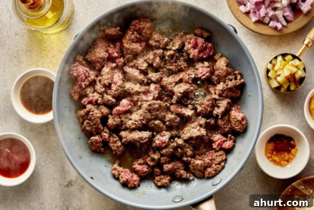 Cheeseburger Bliss Wrap 6 Ground meat cooking in a pan on a stove.