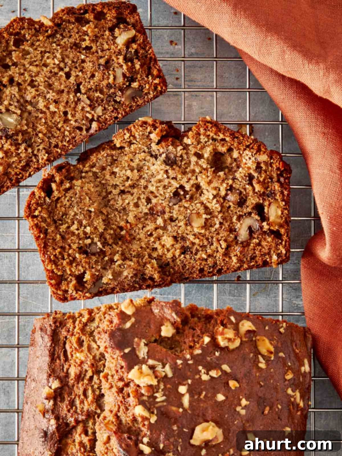 Slices of delicious brown banana bread resting on a wire tray. The bread looks incredibly moist and inviting.