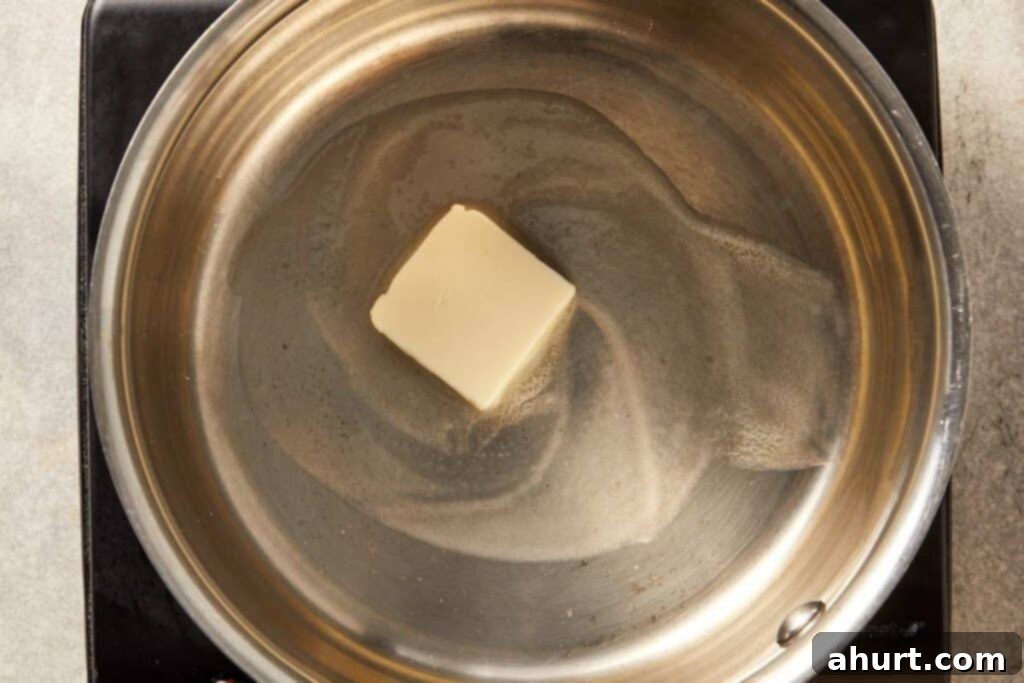 Butter melting in a large pan over medium heat, starting the base for creamy corn recipe