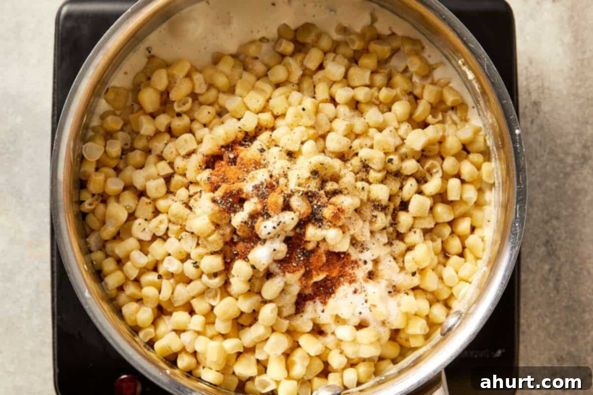 Frozen corn added to a creamy base with salt, black pepper, sugar, and nutmeg, ready to simmer until tender