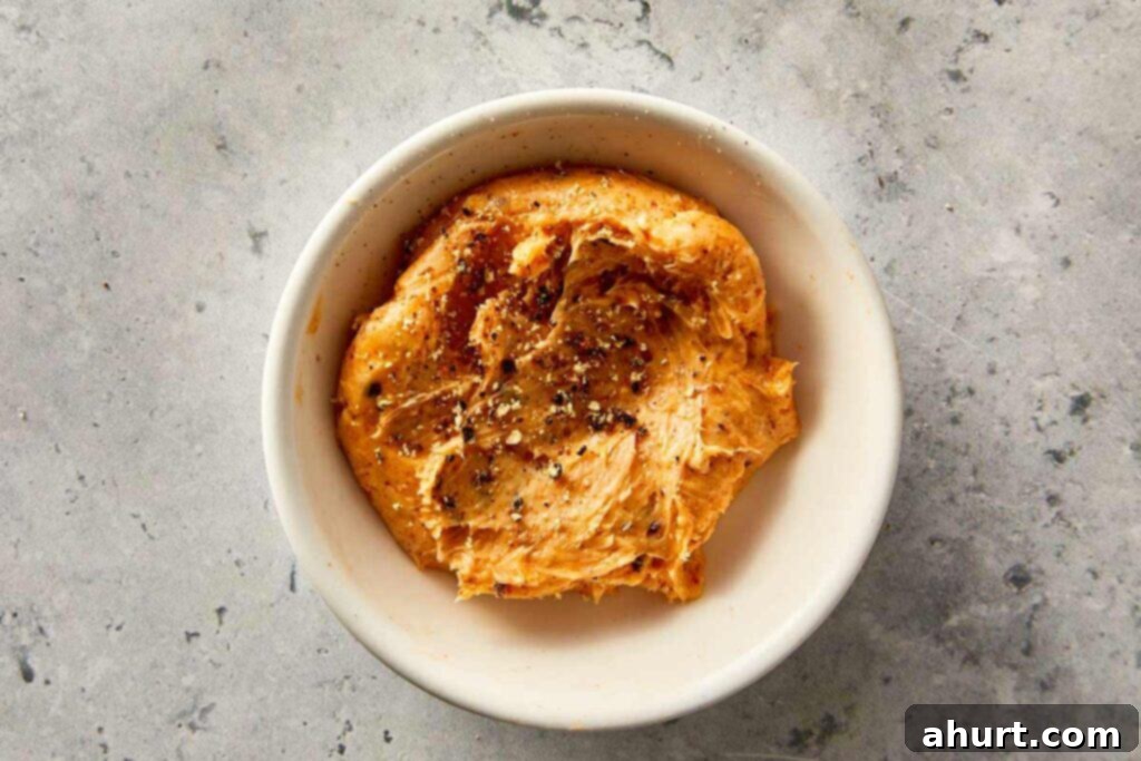 Garlic butter with spices in a small bowl, ready to spread over baked sweet potatoes