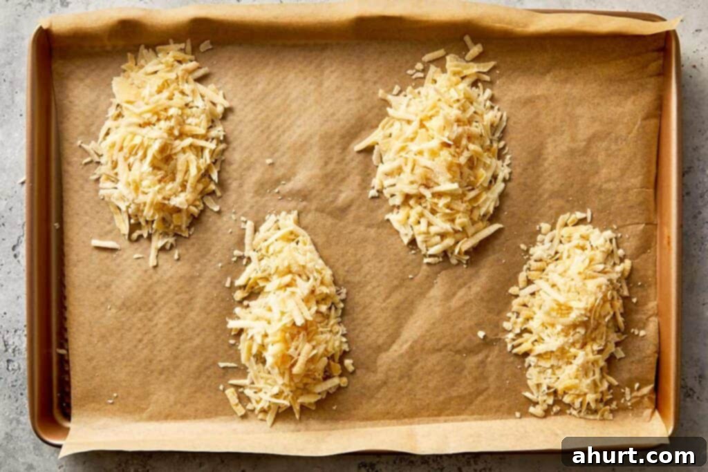 Grated Parmesan on a lined baking tray, ready to go into the oven