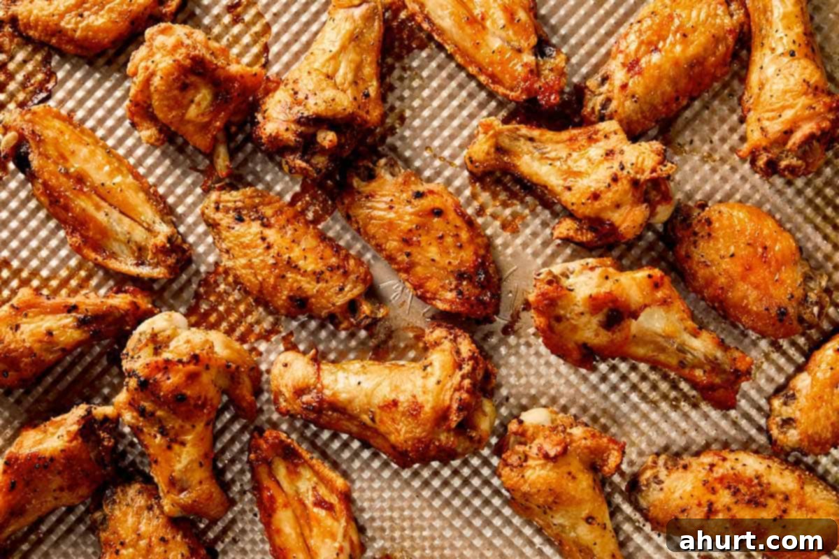 Lemon Pepper Wings: A Zesty Bite of Sunshine 8 Crispy baked lemon pepper chicken wings on a tray, golden and evenly browned with a lightly seasoned coating