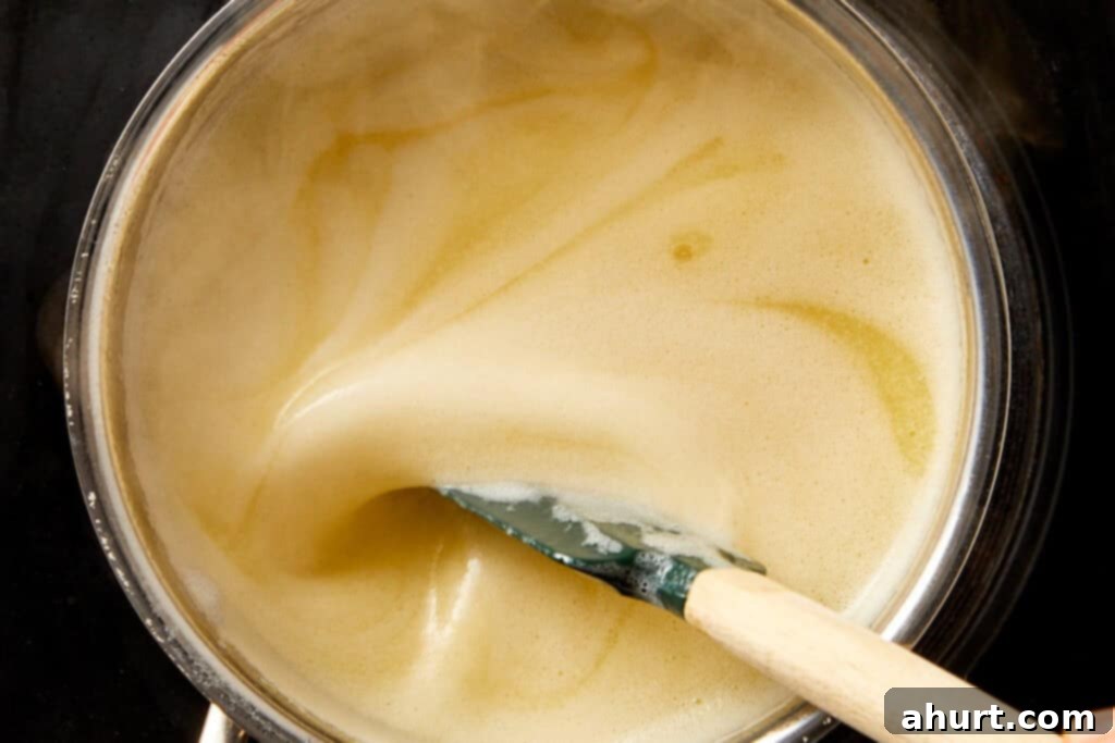 Lemon Pepper Wings: A Zesty Bite of Sunshine 9 Melted butter being whisked in a saucepan over heat, starting the lemon pepper sauce base