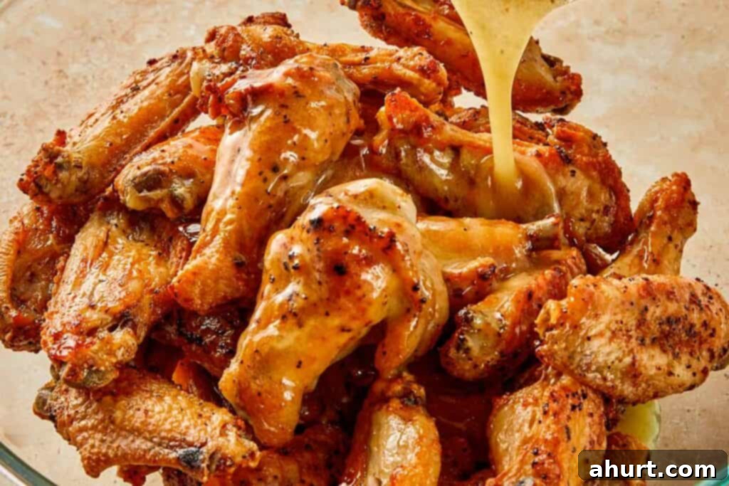 Lemon Pepper Wings: A Zesty Bite of Sunshine 10 Pouring lemon pepper butter sauce over crispy chicken wings, coating them evenly before serving