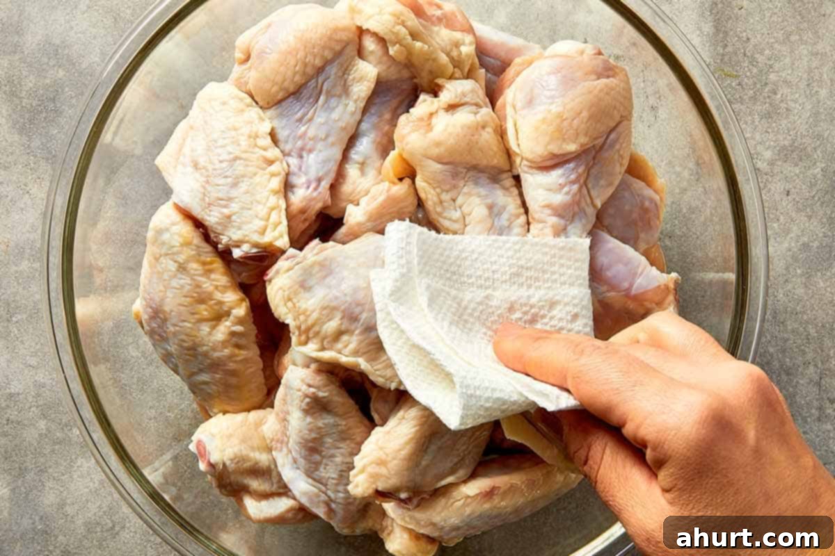 patting raw chicken wings dry with paper towel before seasoning