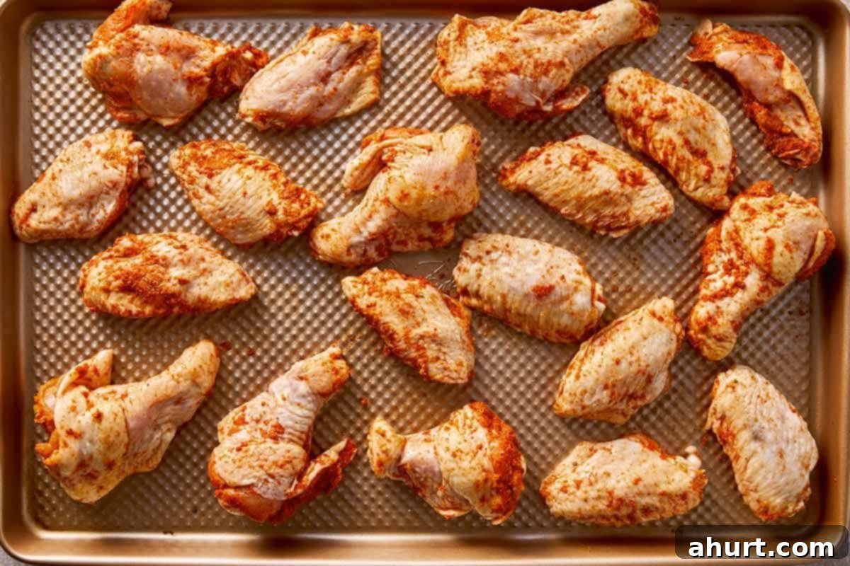 seasoned chicken wings arranged on baking sheet for oven